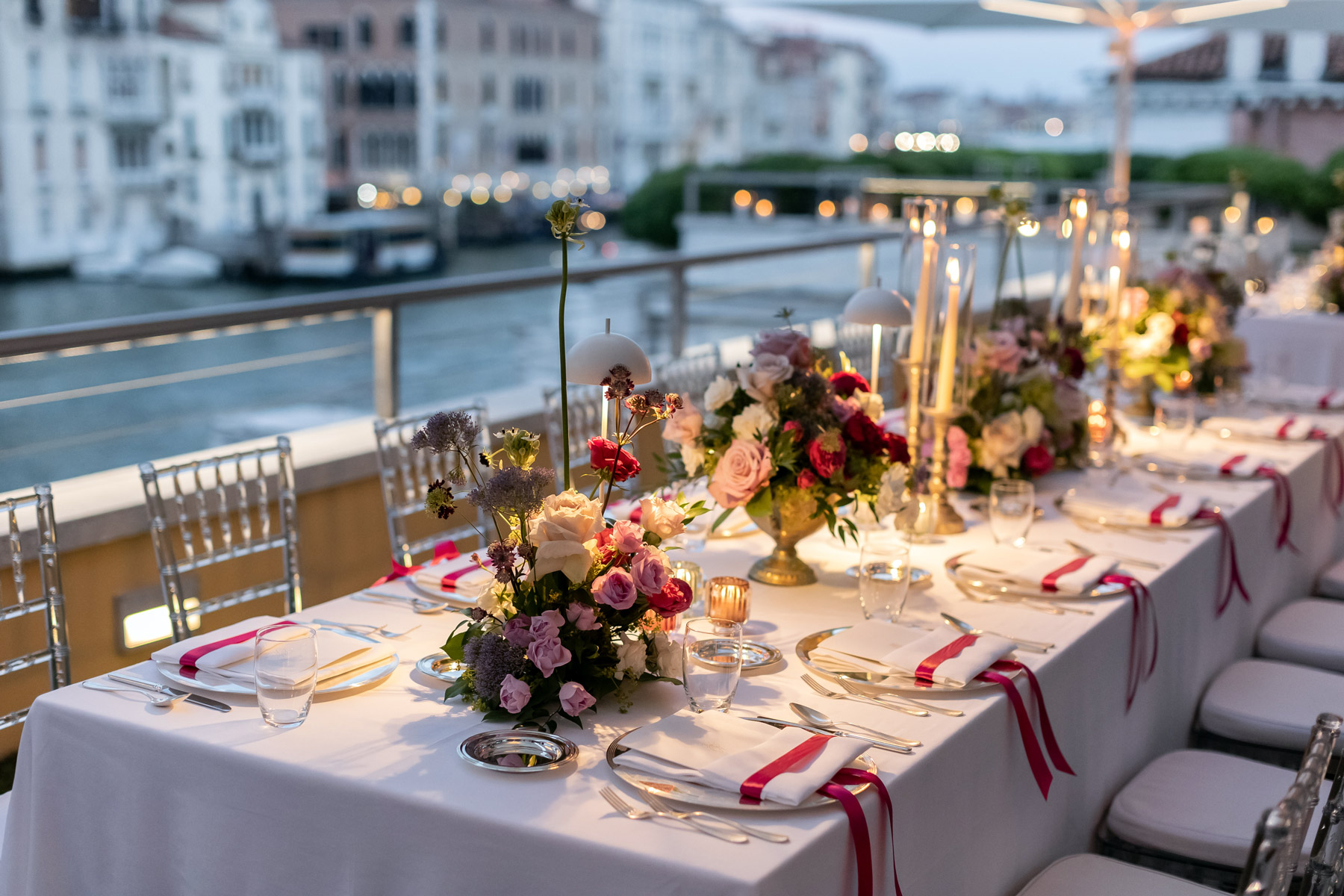 Table set with pink and fuchsia flowers in the center of the table - ACCAELLE Events | Organizzazione eventi e Wedding planner