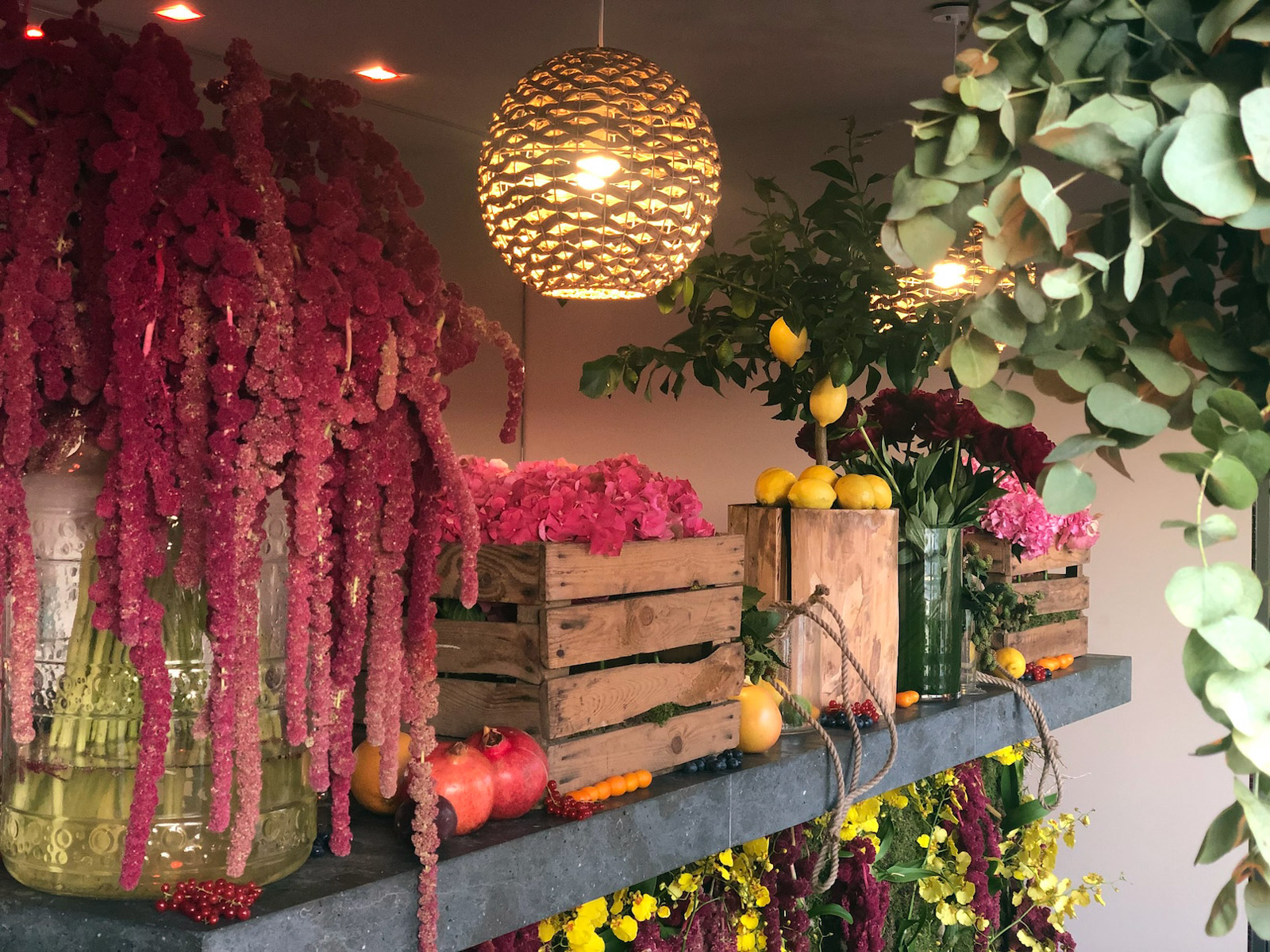 Rustic decor with wooden crates, hanging plants, and a woven rope chandelier. - ACCAELLE Events | Organizzazione eventi e Wedding planner