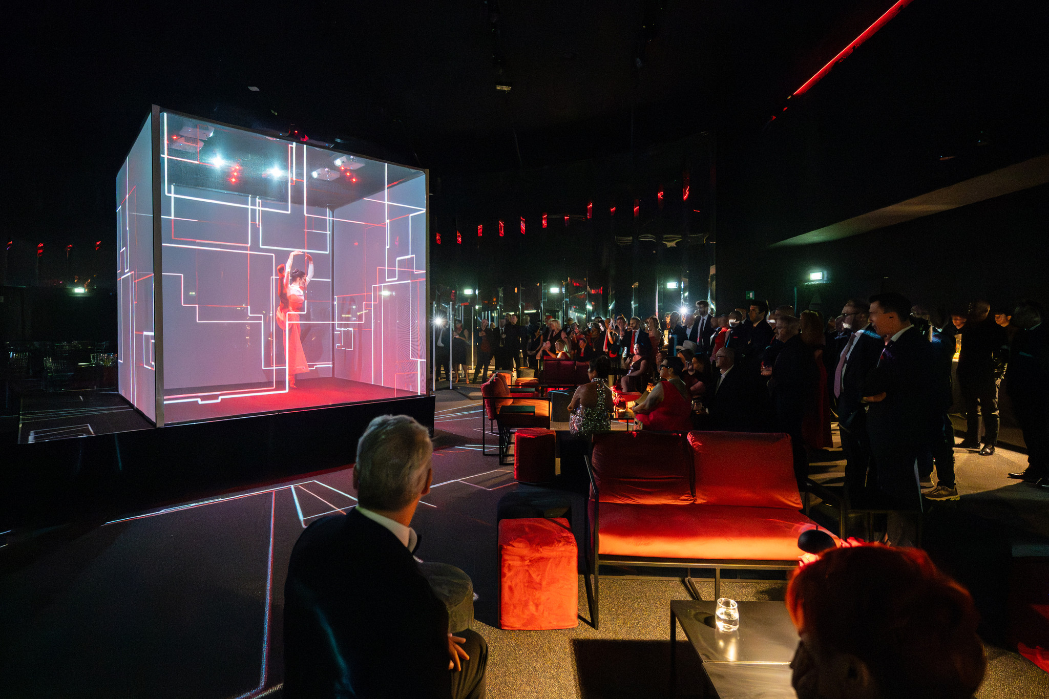 Artist dancing inside a large cubic structure with white and red holographic details that change over time - ACCAELLE Events | Organizzazione eventi e Wedding planner