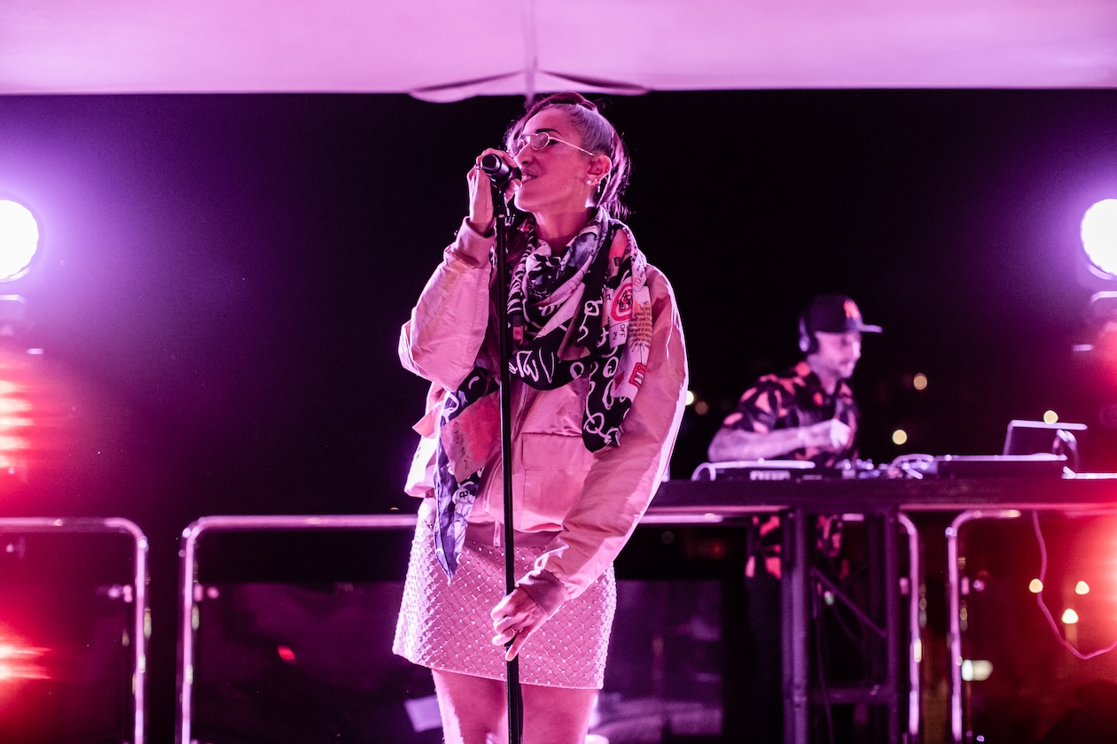 Artist performing singing during the event illuminated by blue and red lights - ACCAELLE Events | Organizzazione eventi e Wedding planner