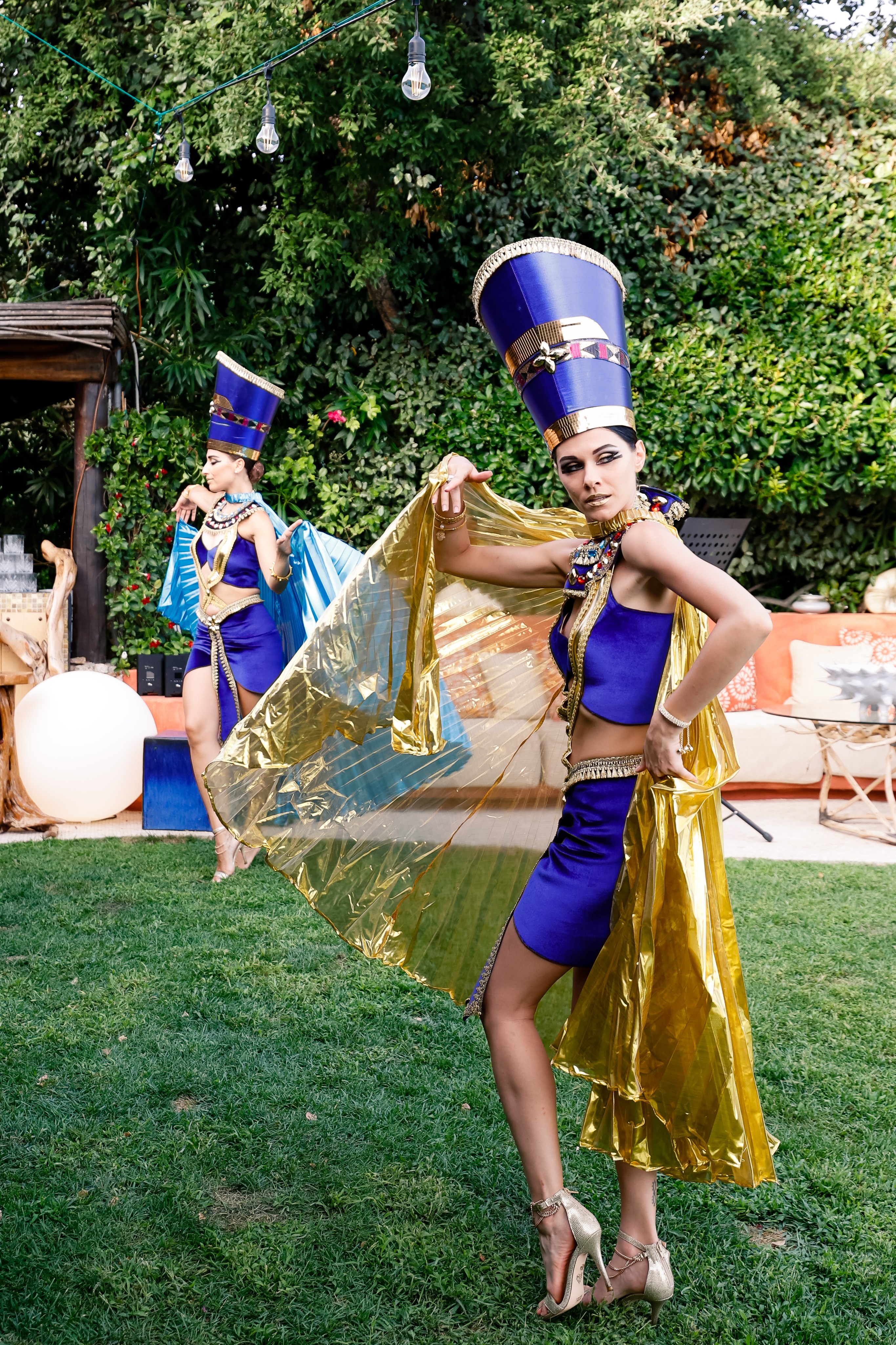 Artist in blue and gold Egyptian costume poses in a garden. - ACCAELLE Events | Organizzazione eventi e Wedding planner