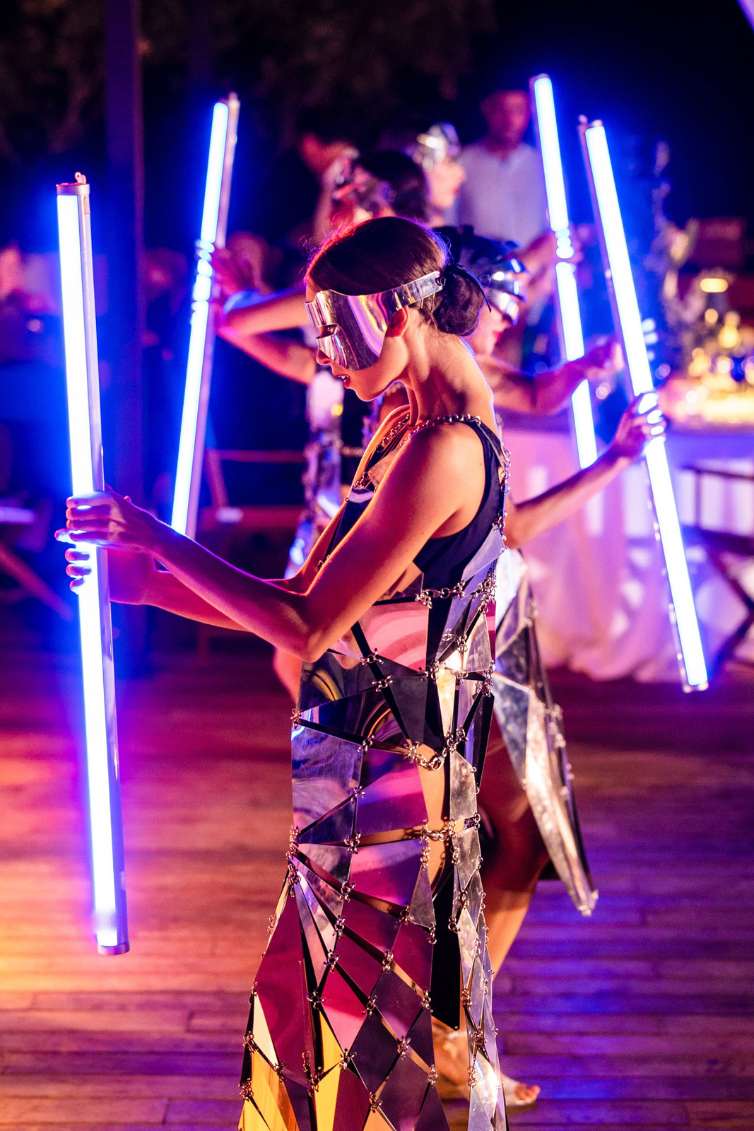 Female artists in dresses with geometric details holding glow sticks - ACCAELLE Events | Organizzazione eventi e Wedding planner