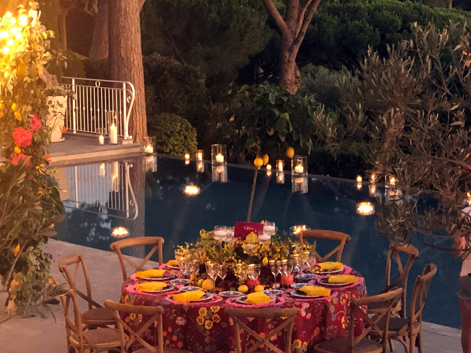Evening atmosphere by the pool with tables lit by warm candlelight. - ACCAELLE Events | Organizzazione eventi e Wedding planner