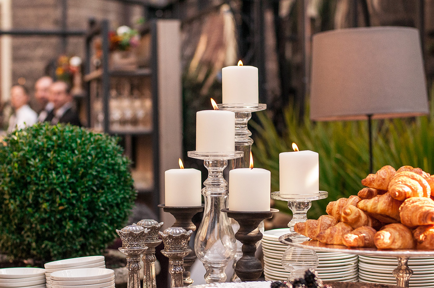 Detail of the wedding buffet with cylindrical candles, decorative plants and croissants. - ACCAELLE Events | Organizzazione eventi e Wedding planner