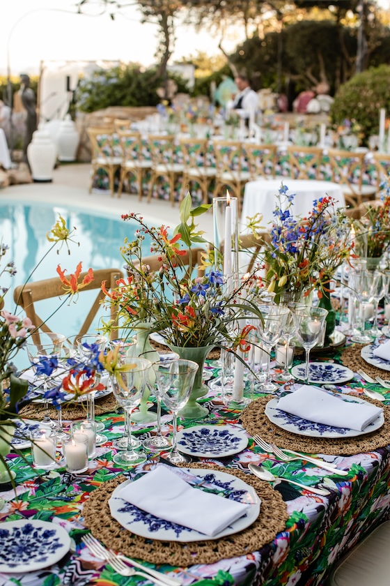 Detail of the summer table setting with blue plates and straw placemats by the pool. - ACCAELLE Events | Organizzazione eventi e Wedding planner