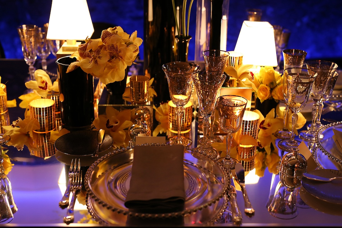 Detail of a table set with yellow flowers, crystal glasses, and soft lighting. - ACCAELLE Events | Organizzazione eventi e Wedding planner