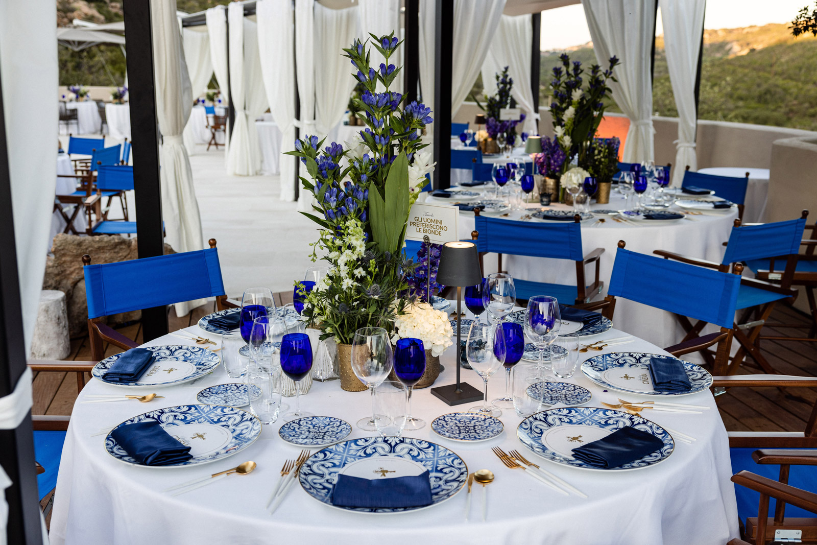 Detail of a round table elegantly set with a white tablecloth and blue plates - ACCAELLE Events | Organizzazione eventi e Wedding planner