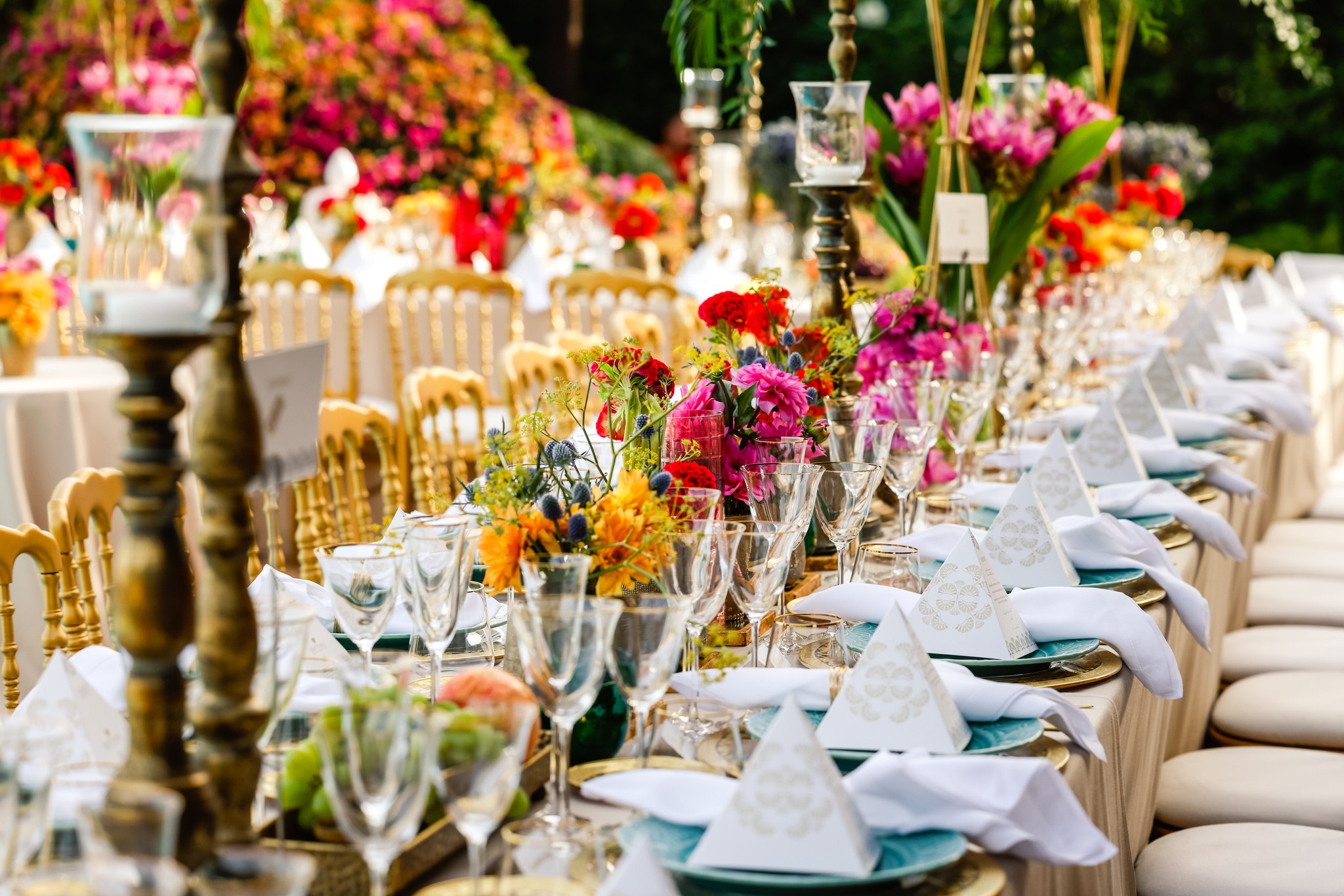 Detail of a table with candelabras and bright floral arrangements in the garden - ACCAELLE Events | Organizzazione eventi e Wedding planner