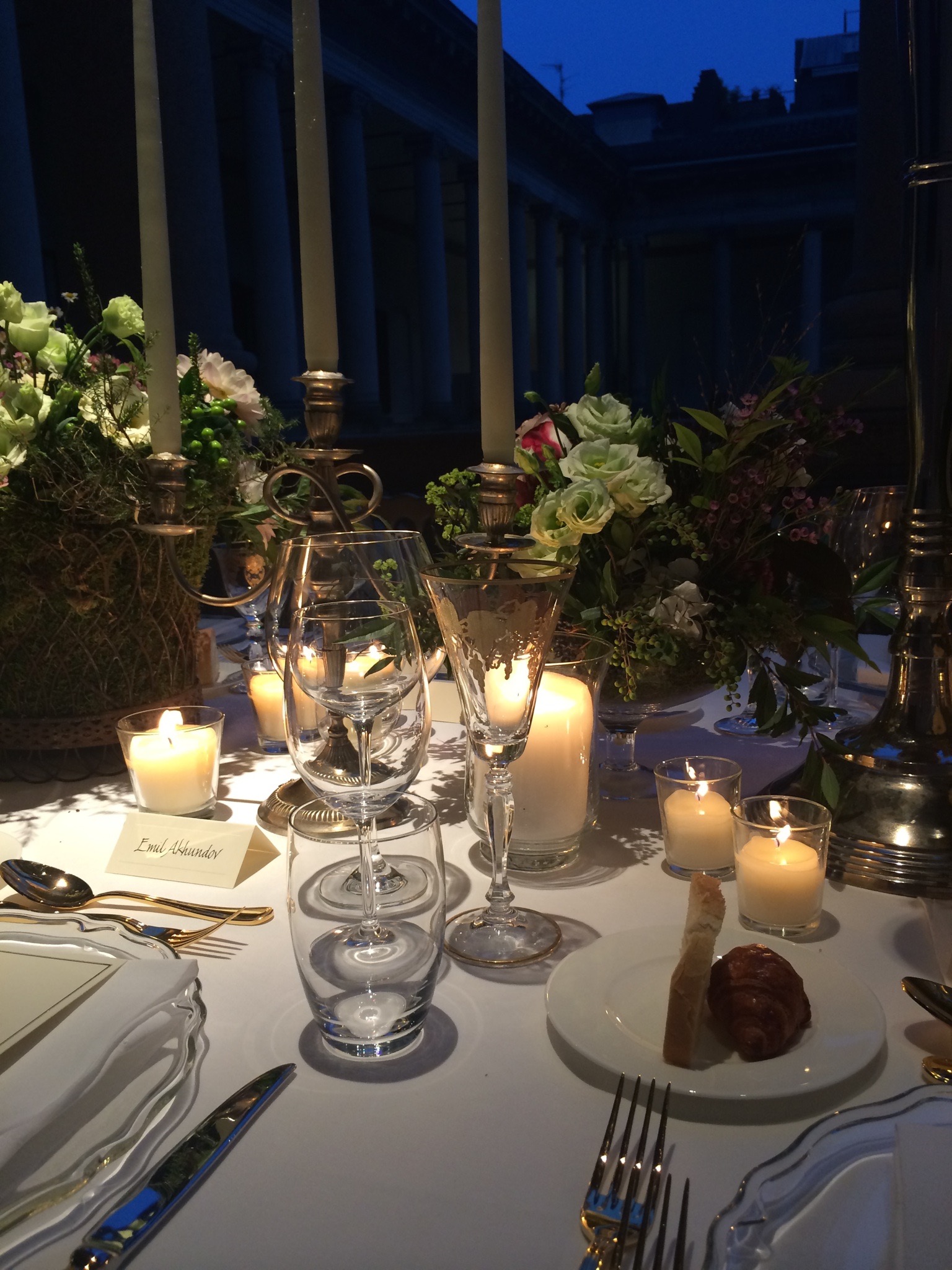 Evening table setting detail with lit candles reflecting the light on the glasses. - ACCAELLE Events | Organizzazione eventi e Wedding planner