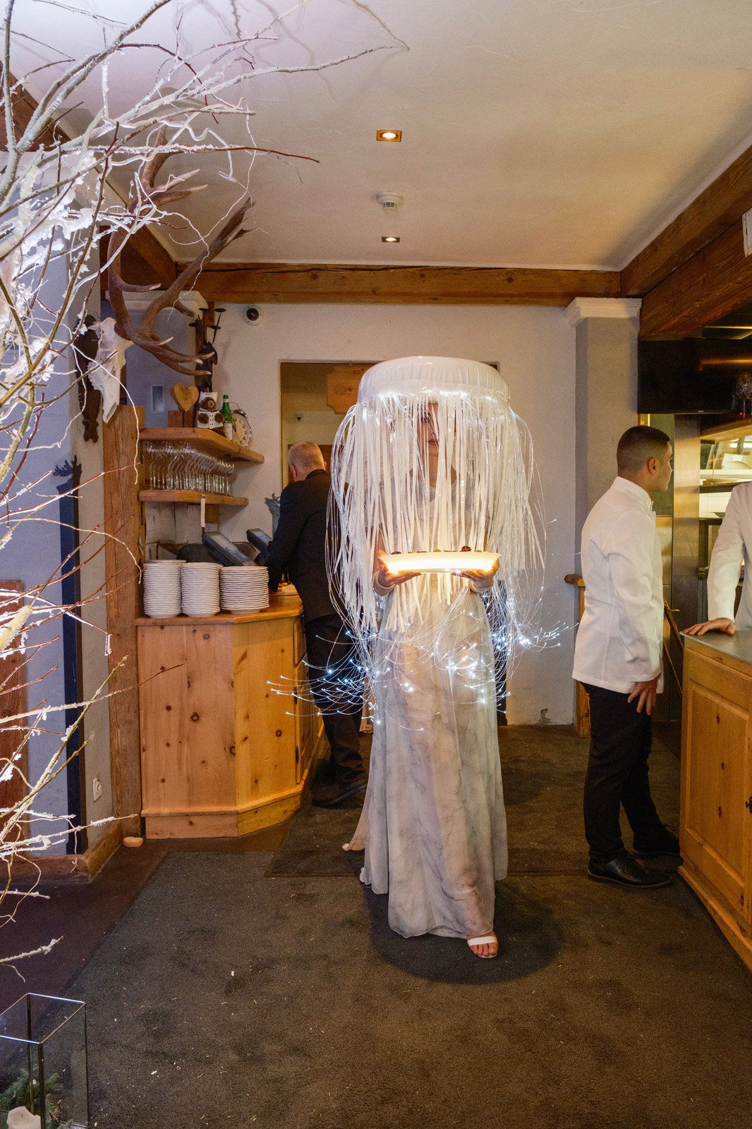 Woman in white dress and white opulent headdress carrying a tray - ACCAELLE Events | Organizzazione eventi e Wedding planner