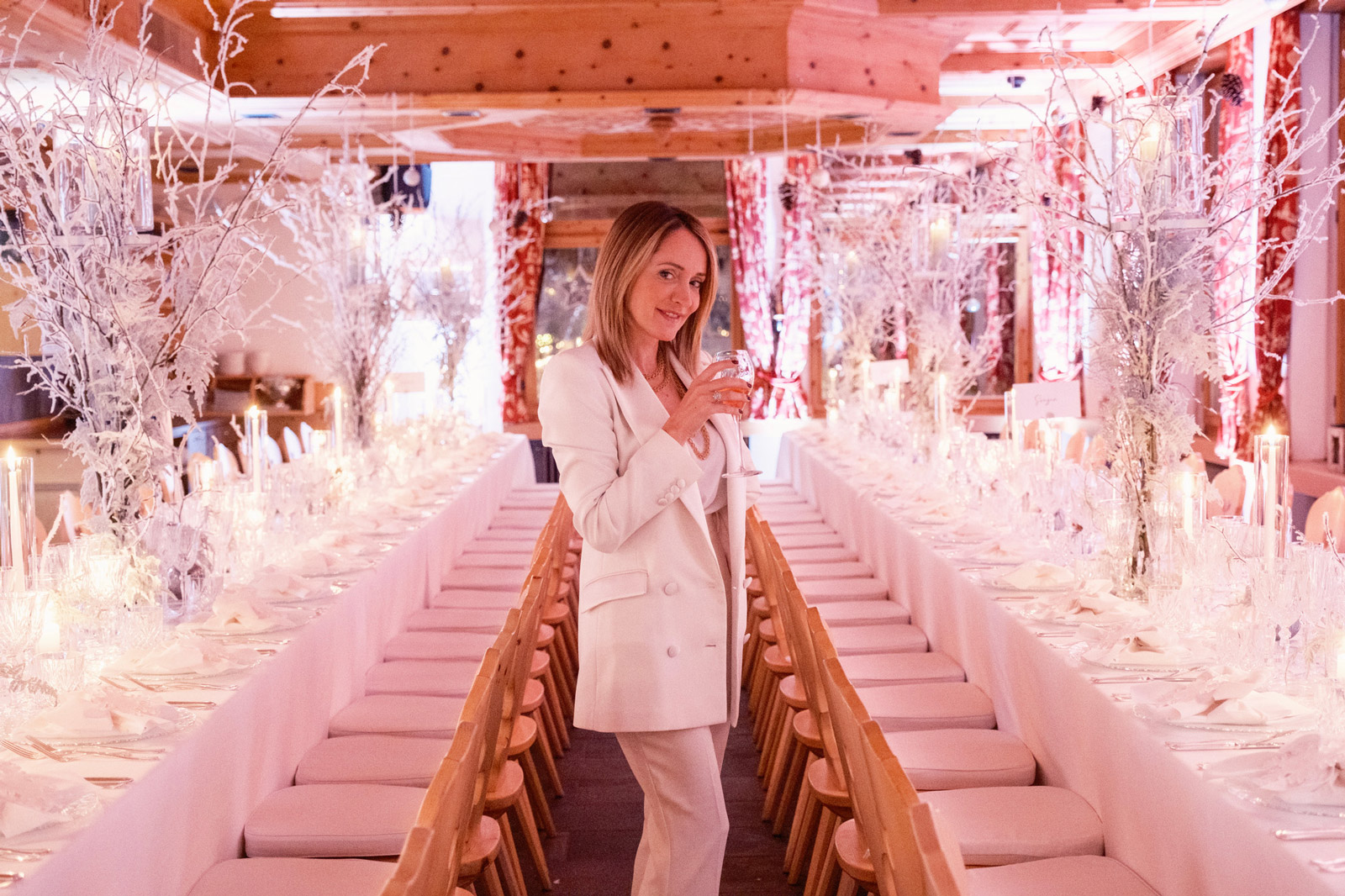 Woman in an elegant white suit poses inside a room set up for a luxury winter event - ACCAELLE Events | Organizzazione eventi e Wedding planner