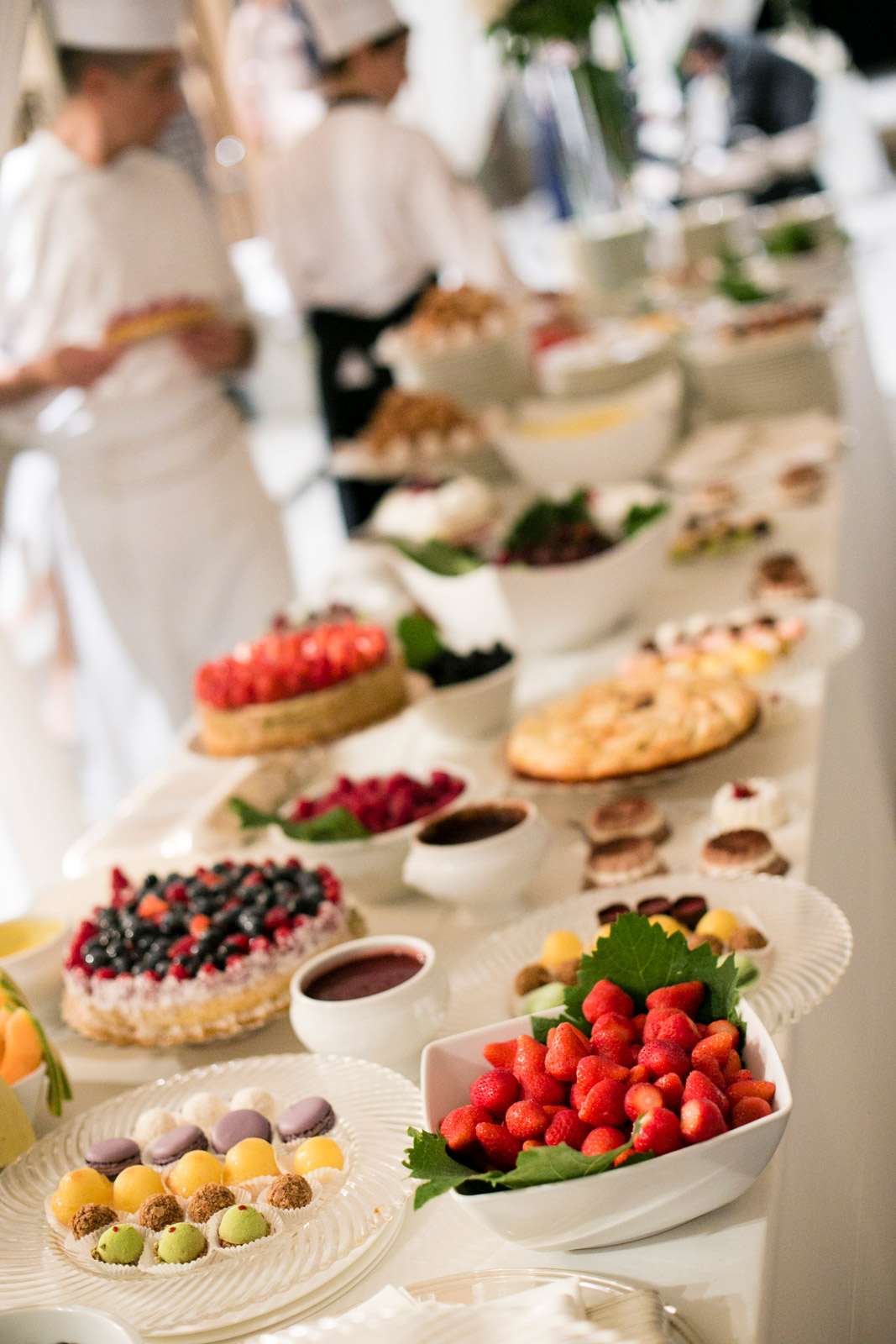 Large buffet of desserts and fruit with waiters in the background - ACCAELLE Events | Organizzazione eventi e Wedding planner