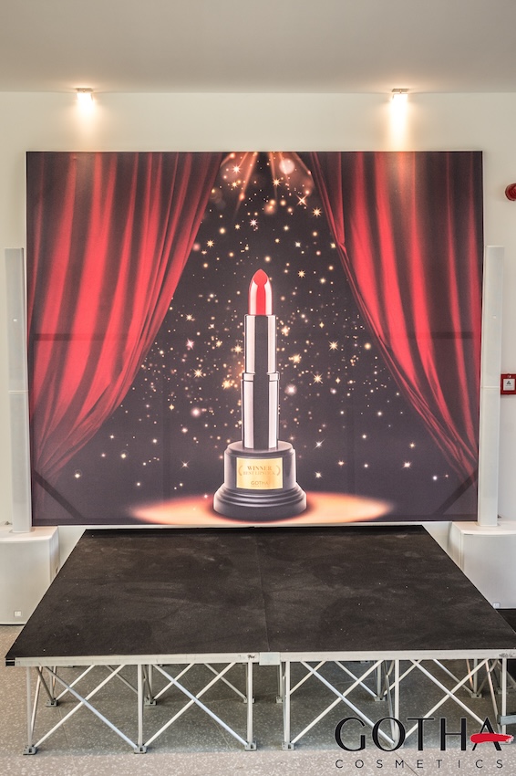 Image of stage with red curtains and lipstick in the center with small stage placed underneath - ACCAELLE Events | Organizzazione eventi e Wedding planner