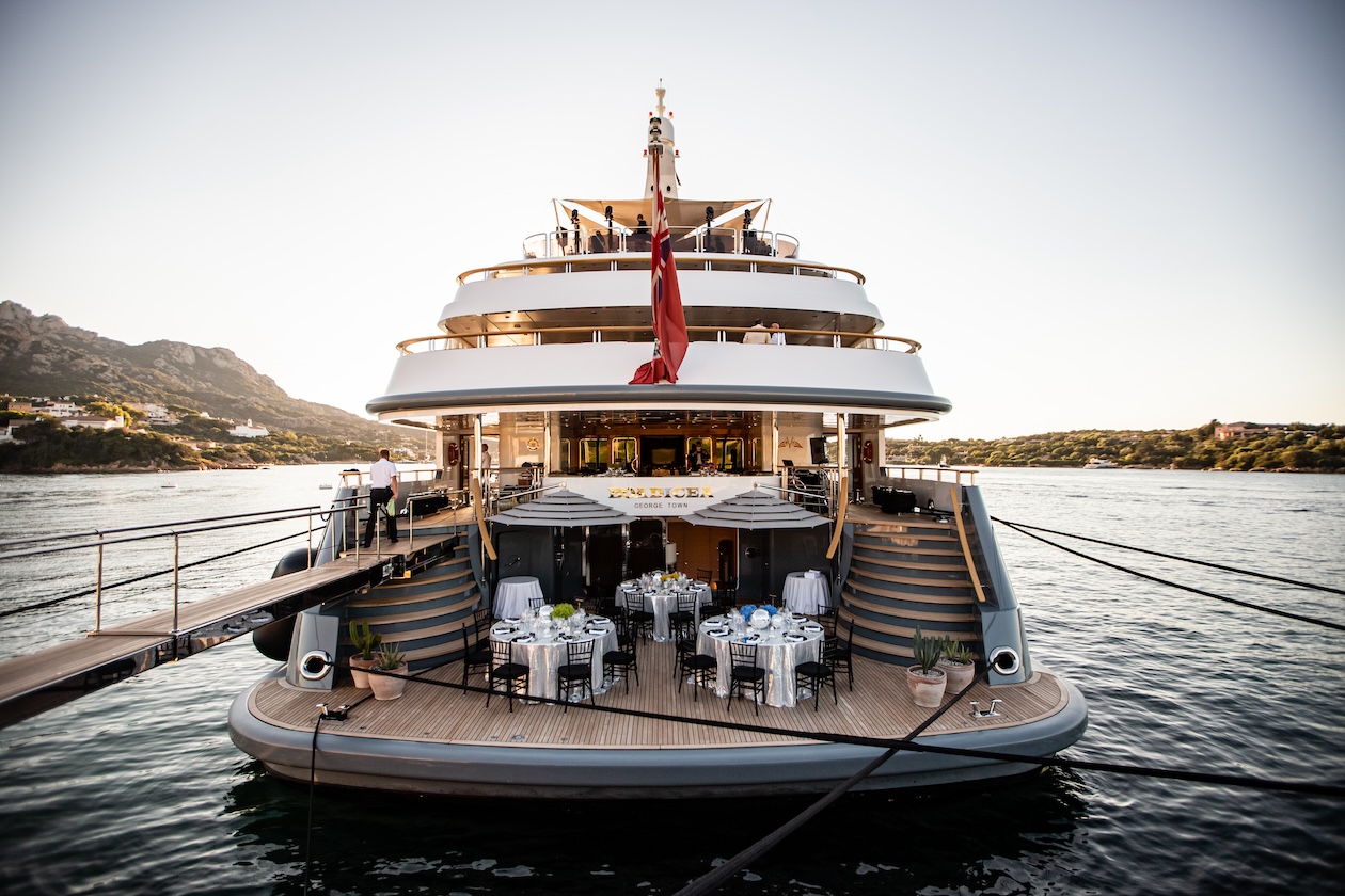 Impressive luxury yacht moored in the water seen from the stern during sunset. - ACCAELLE Events | Organizzazione eventi e Wedding planner