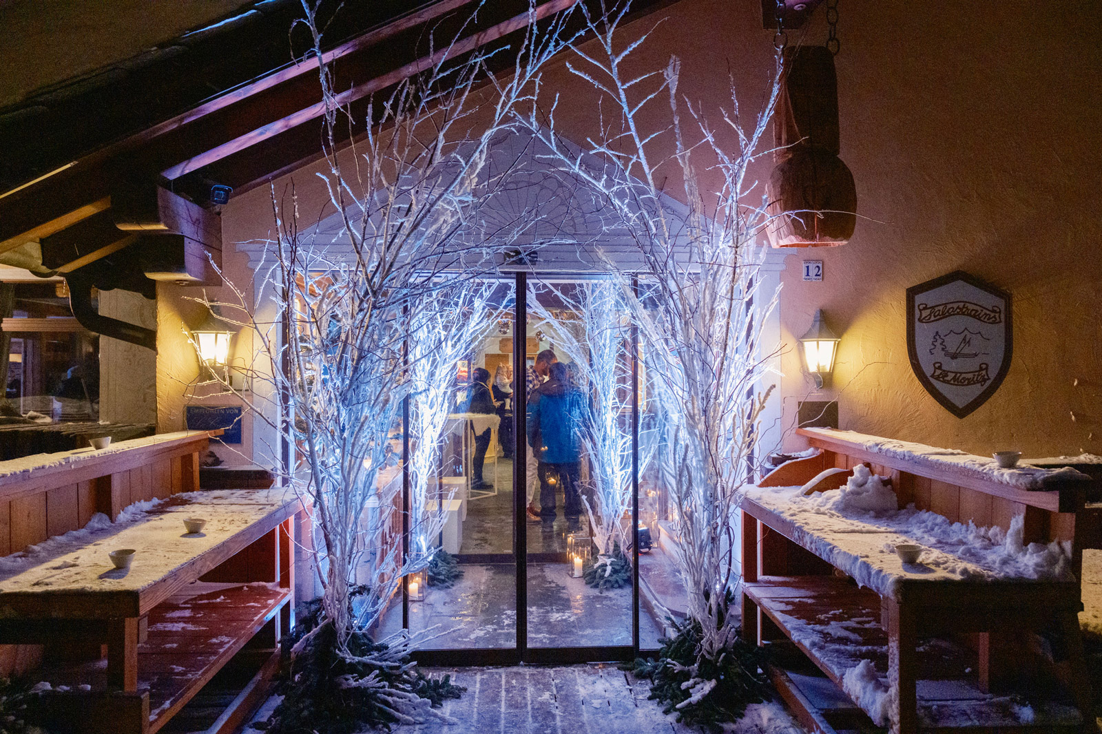 Winter event entrance decorated with illuminated white branches, creating a magical effect inspired by a snowy forest - ACCAELLE Events | Organizzazione eventi e Wedding planner