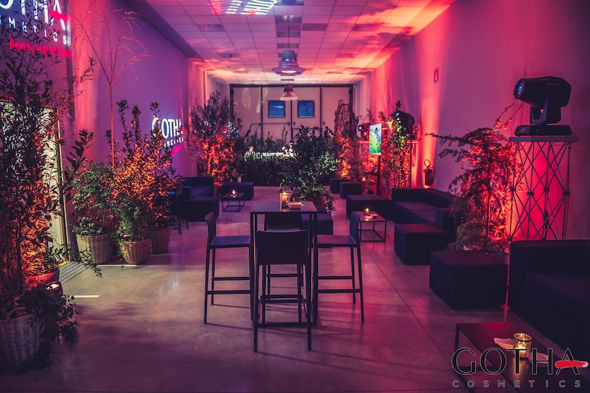 Corporate event interior at Gotha Cosmetics, featuring red LED lighting, decorative plants, and modern lounge furniture. - ACCAELLE Events | Organizzazione eventi e Wedding planner