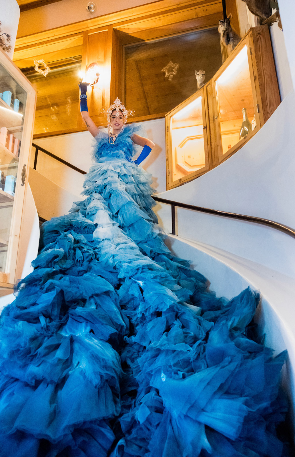 Model in elegant light blue and blue dress posing on a bright staircase - ACCAELLE Events | Organizzazione eventi e Wedding planner