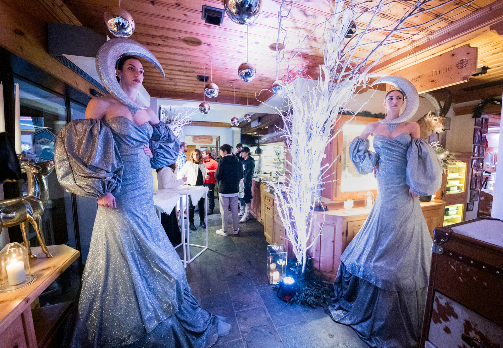 Models in elegant grey glitter evening dresses with eye-catching moon-shaped headpieces, posing next to bright branches - ACCAELLE Events | Organizzazione eventi e Wedding planner