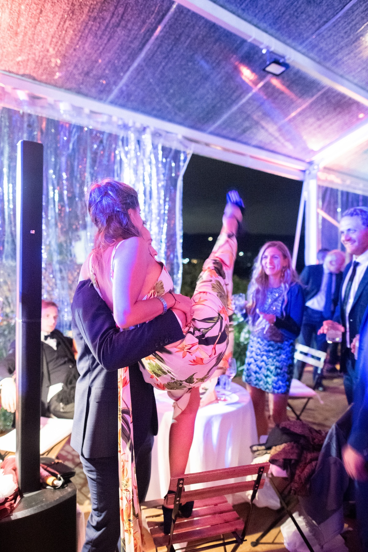 A moment of celebration with people dancing and lifting the bride in a dynamic setting. - ACCAELLE Events | Organizzazione eventi e Wedding planner