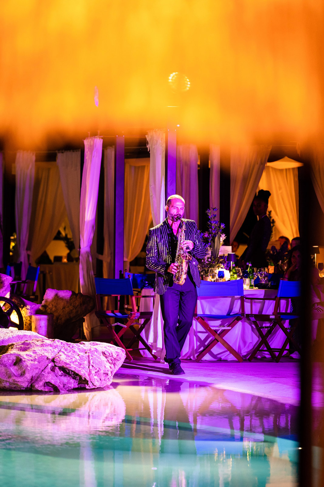 Musician playing a trumpet by the pool in the evening - ACCAELLE Events | Organizzazione eventi e Wedding planner
