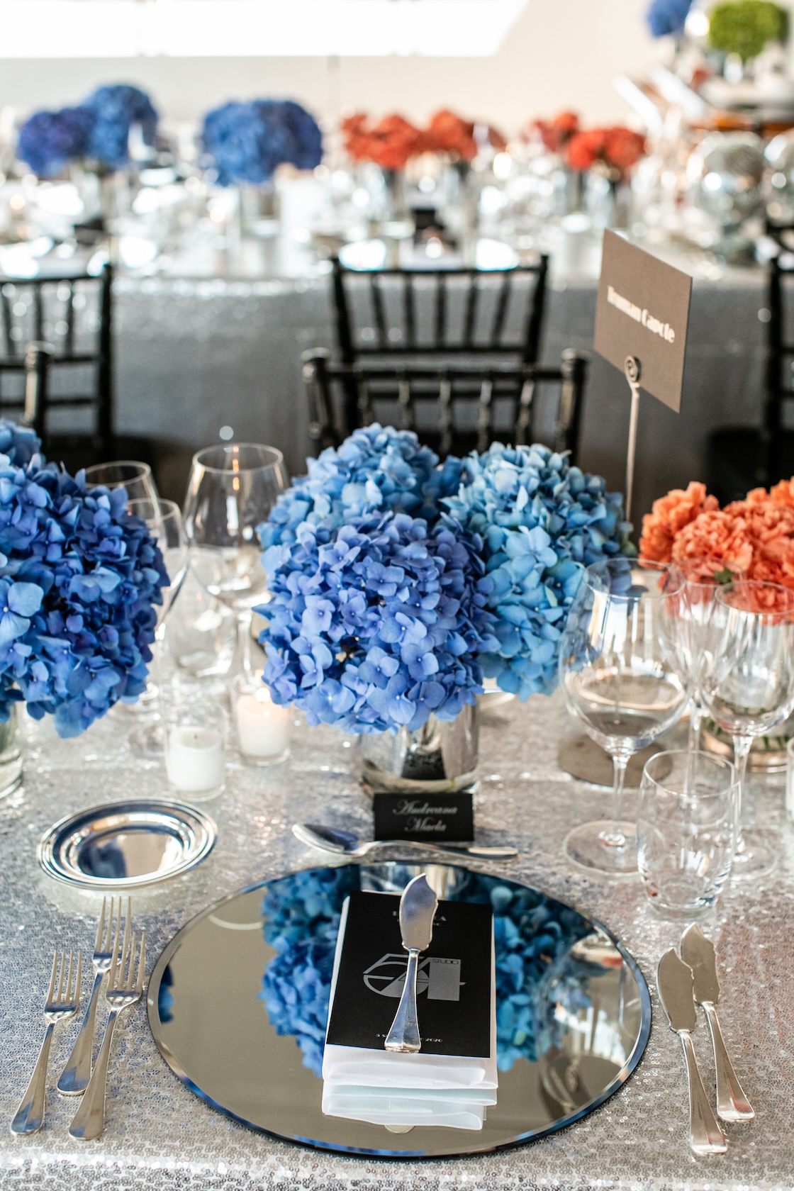 Close-up of a bright blue hydrangea arrangement on a mirrored coaster. - ACCAELLE Events | Organizzazione eventi e Wedding planner