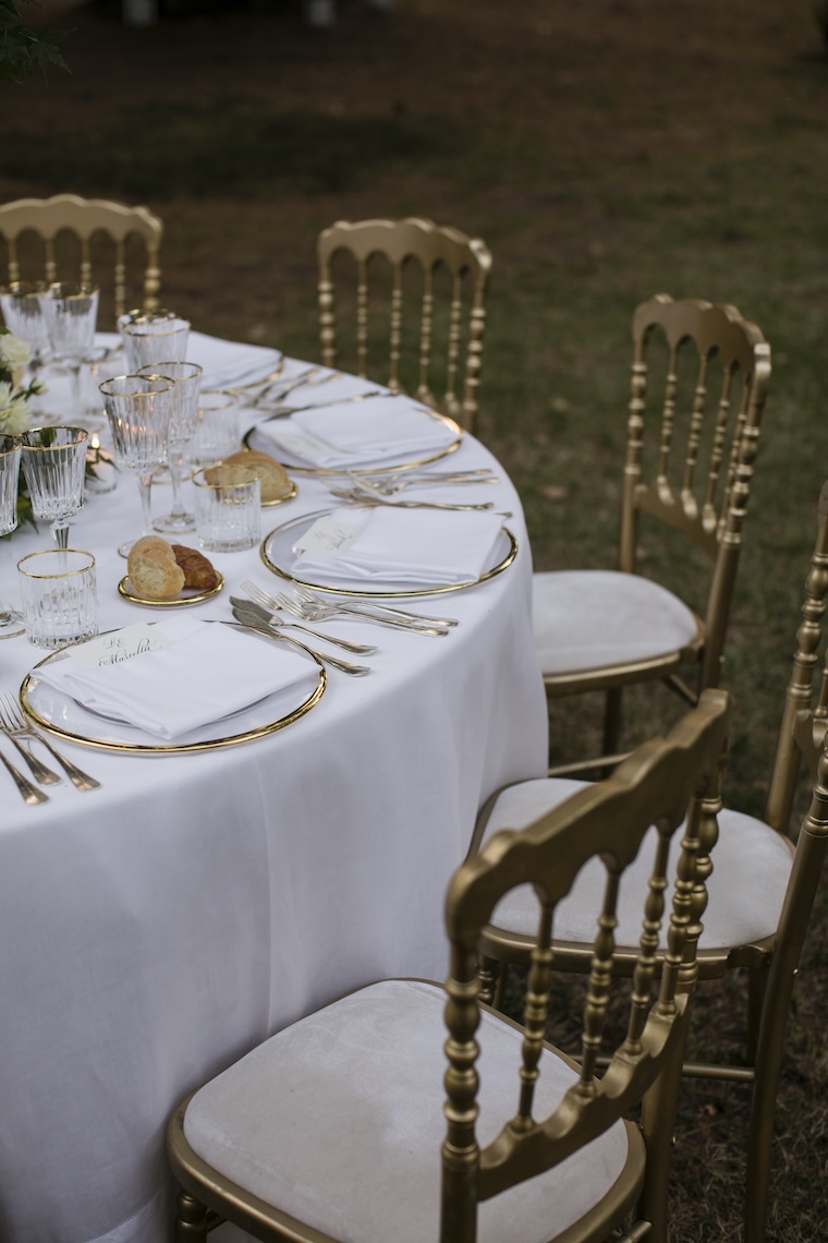 Close-up of an elegantly set round table and chairs with matte gold details - ACCAELLE Events | Organizzazione eventi e Wedding planner