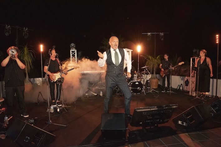 Pucci performing on stage with a musical band - ACCAELLE Events | Organizzazione eventi e Wedding planner