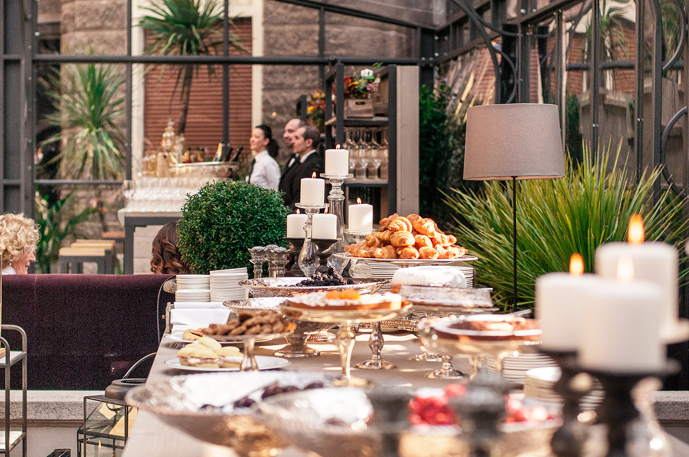 A rich sweet buffet is set up inside the structure with plants and lamps. - ACCAELLE Events | Organizzazione eventi e Wedding planner