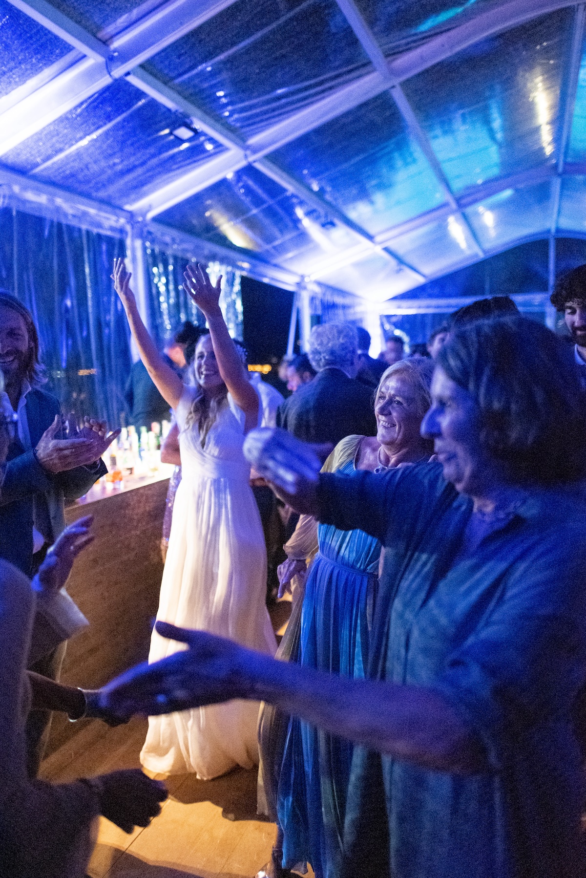 Bride dancing happily on the dance floor surrounded by guests in a festive atmosphere. - ACCAELLE Events | Organizzazione eventi e Wedding planner