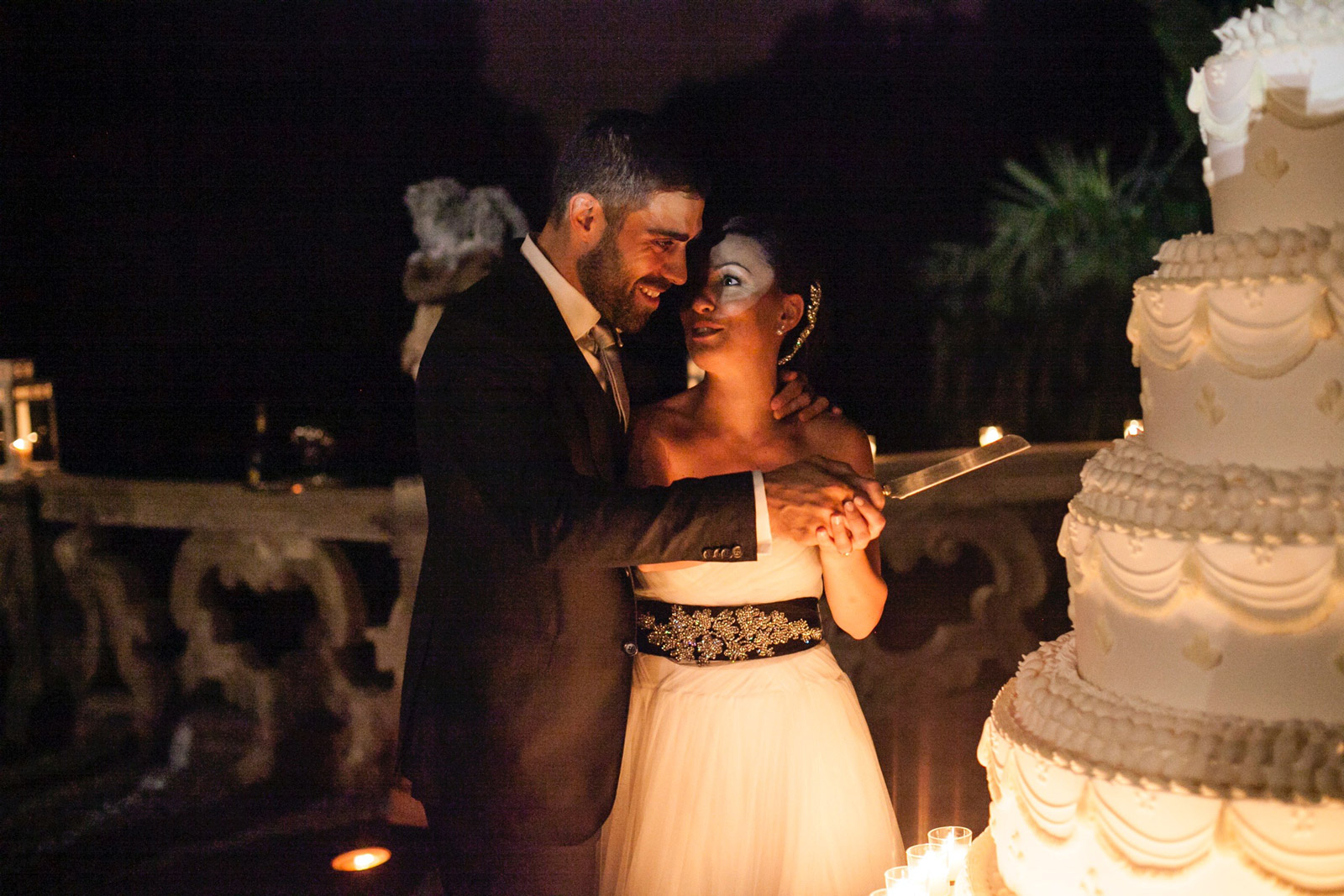 A newlywed couple embracing and smiling outdoors during an evening wedding reception. - ACCAELLE Events | Organizzazione eventi e Wedding planner