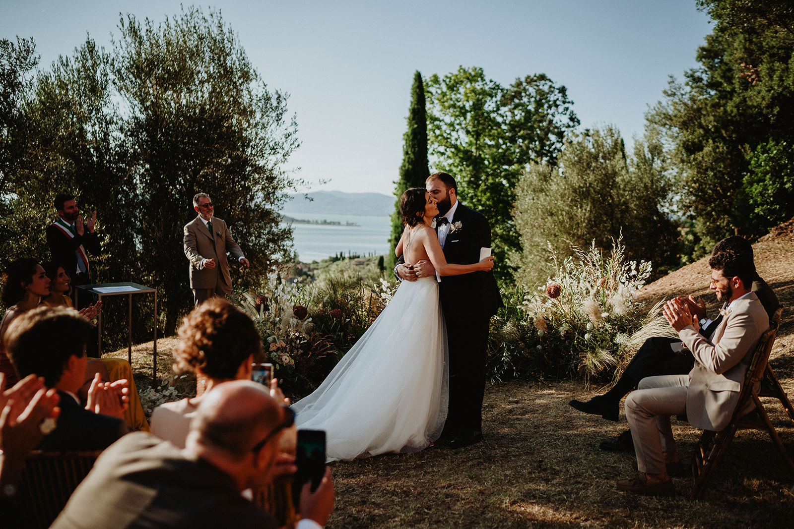 Newlyweds kissing during the ceremony in a garden with a seascape in the background - ACCAELLE Events | Organizzazione eventi e Wedding planner