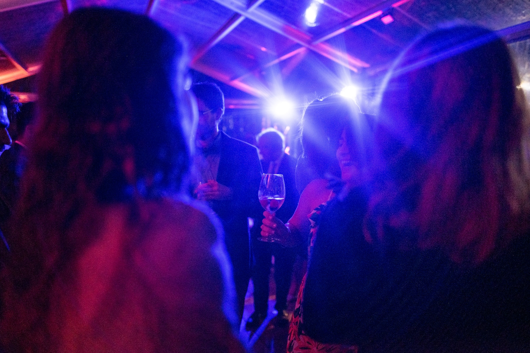 Evocative disco atmosphere with blue and purple lights illuminating party guests. - ACCAELLE Events | Organizzazione eventi e Wedding planner