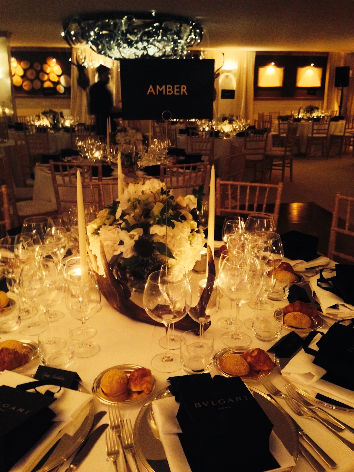 Elegantly set table for a Bulgari event, featuring a floral centerpiece and candles - ACCAELLE Events | Organizzazione eventi e Wedding planner