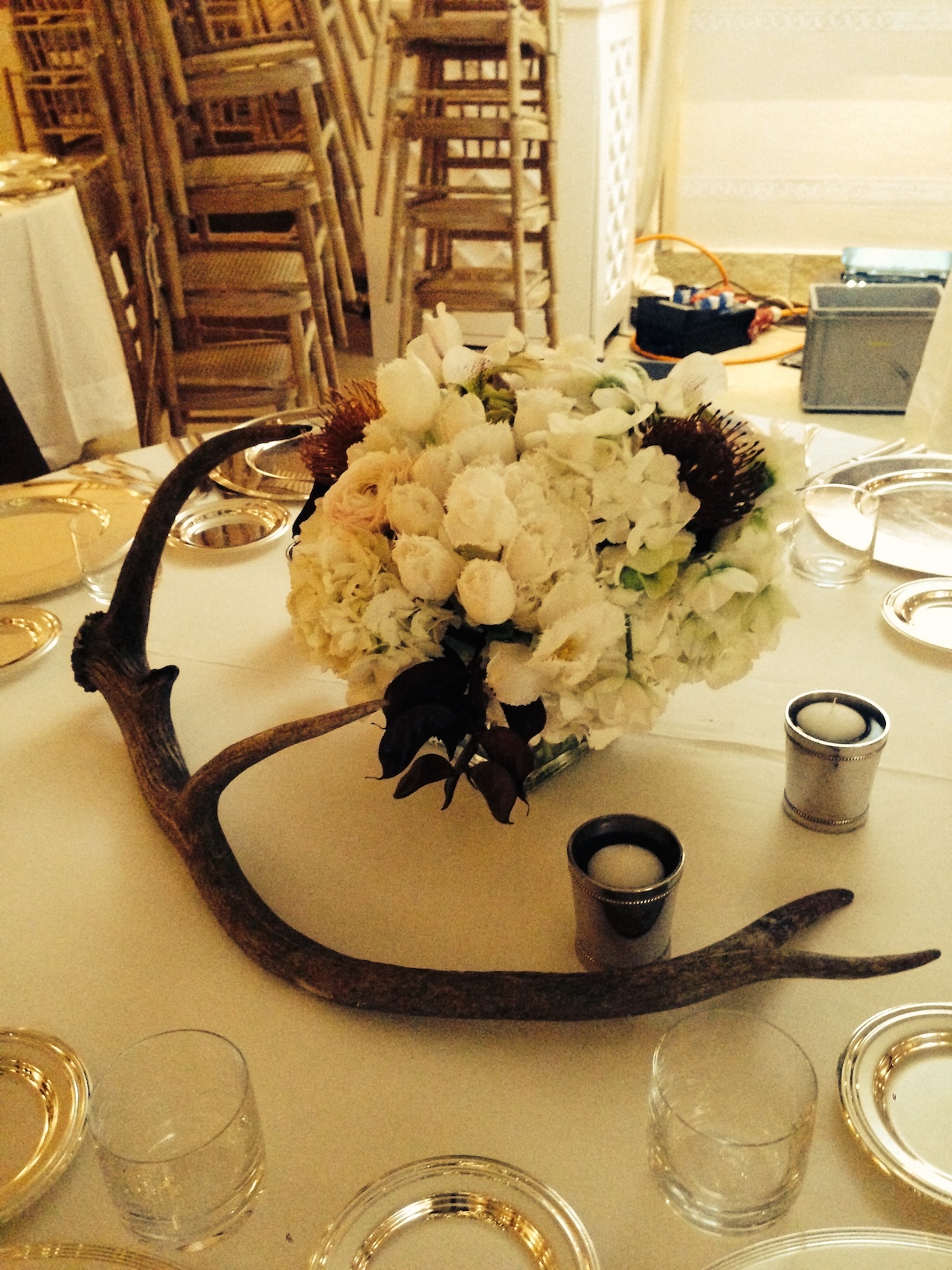 Table set with a white tablecloth, an animal's stage and a basket of flowers placed in the center of the table - ACCAELLE Events | Organizzazione eventi e Wedding planner