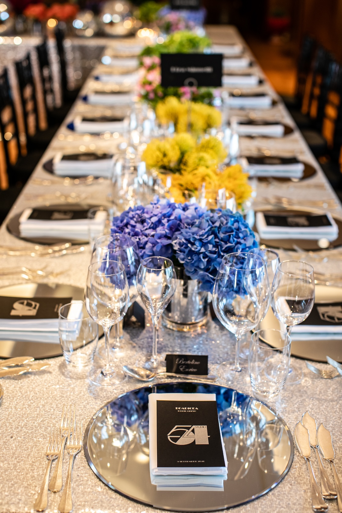 Imperial table decorated with bright blue hydrangeas and yellow flowers in glass vases. - ACCAELLE Events | Organizzazione eventi e Wedding planner