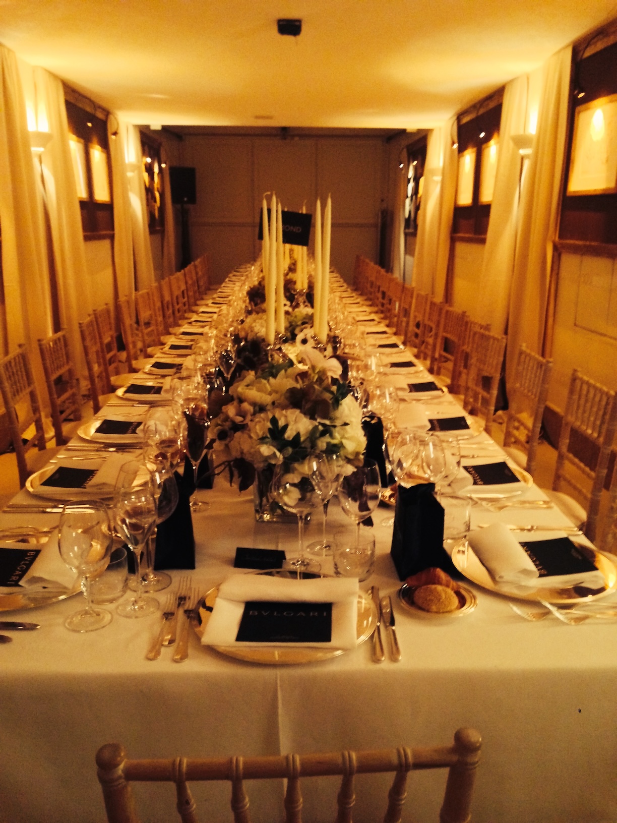 Long table elegantly set with flower baskets and soft warm lighting - ACCAELLE Events | Organizzazione eventi e Wedding planner