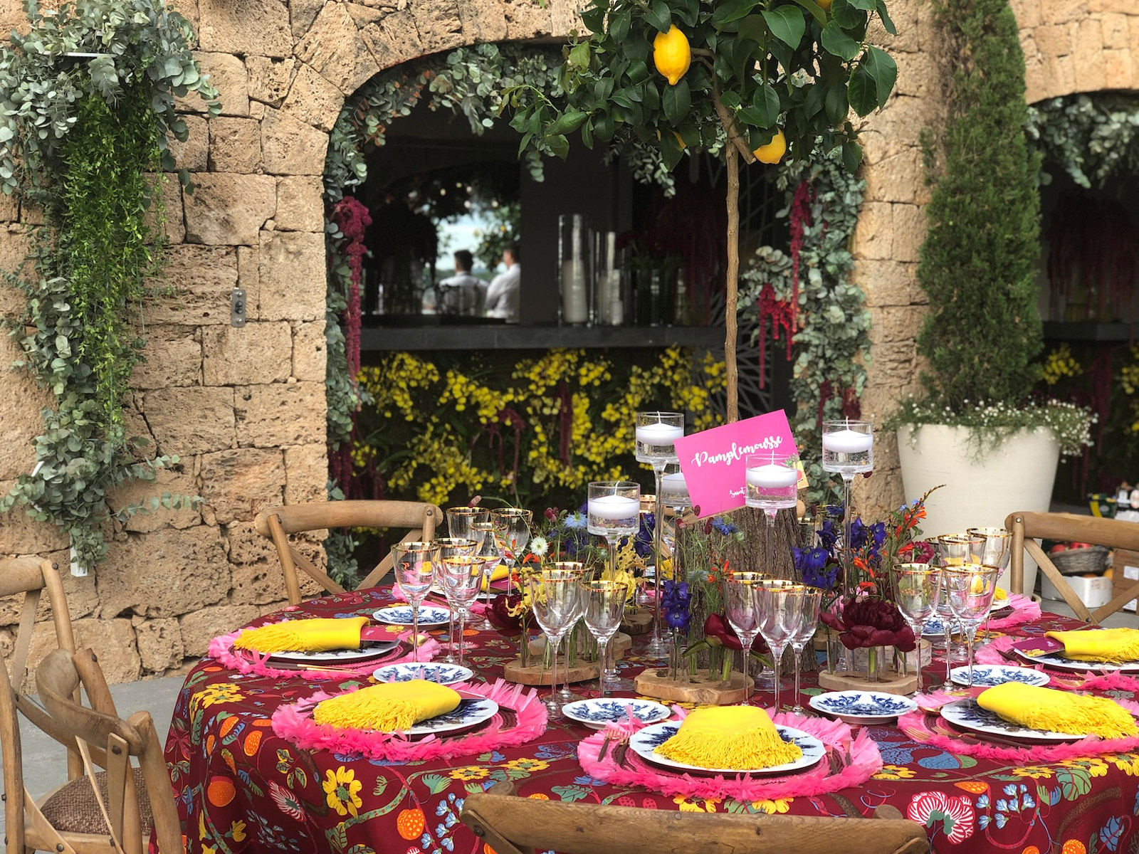 Round table with colorful tablecloth and yellow and fuchsia plates. - ACCAELLE Events | Organizzazione eventi e Wedding planner