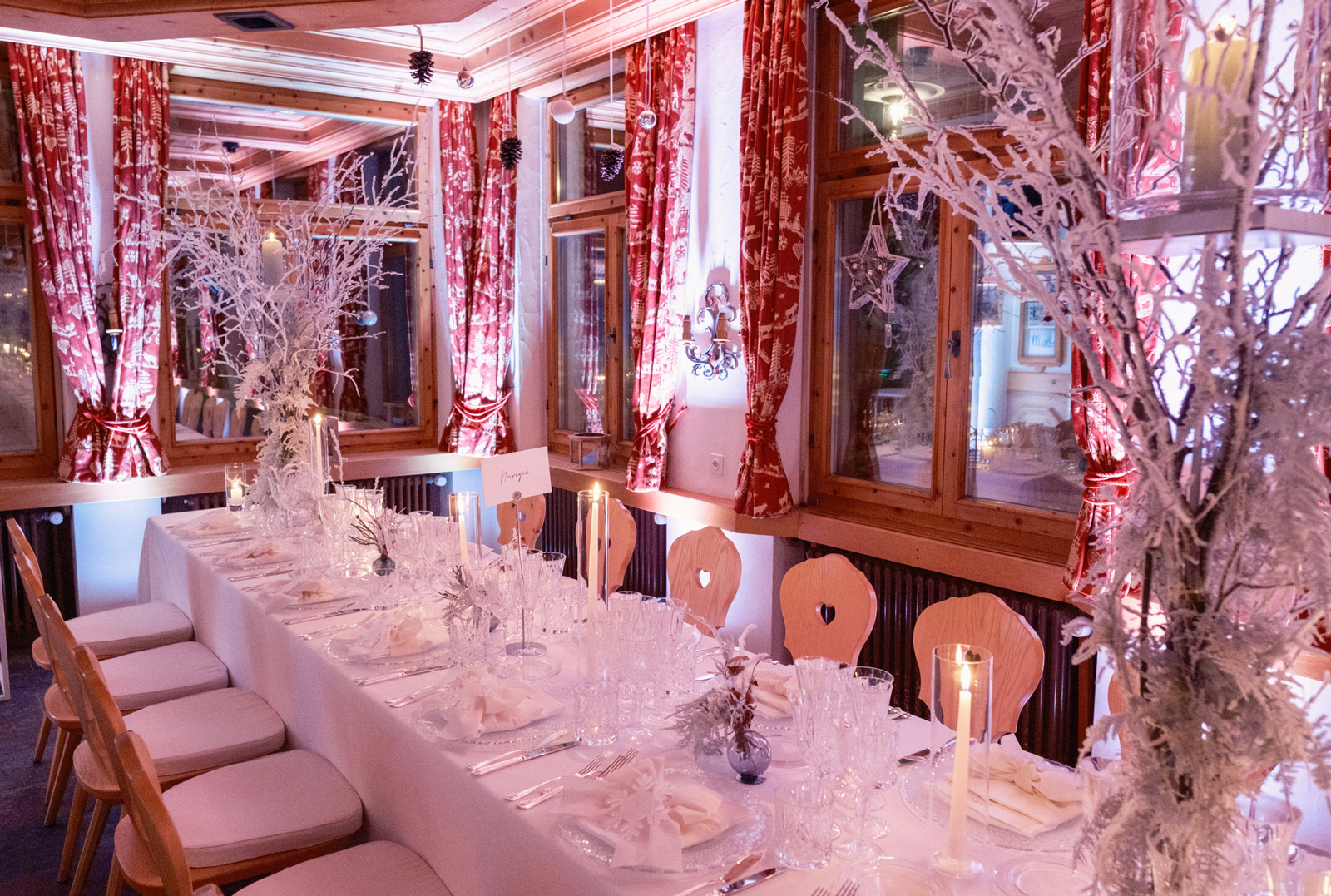 View of a mountain chalet-style reception room, transformed with a white decor and snow-covered branches - ACCAELLE Events | Organizzazione eventi e Wedding planner