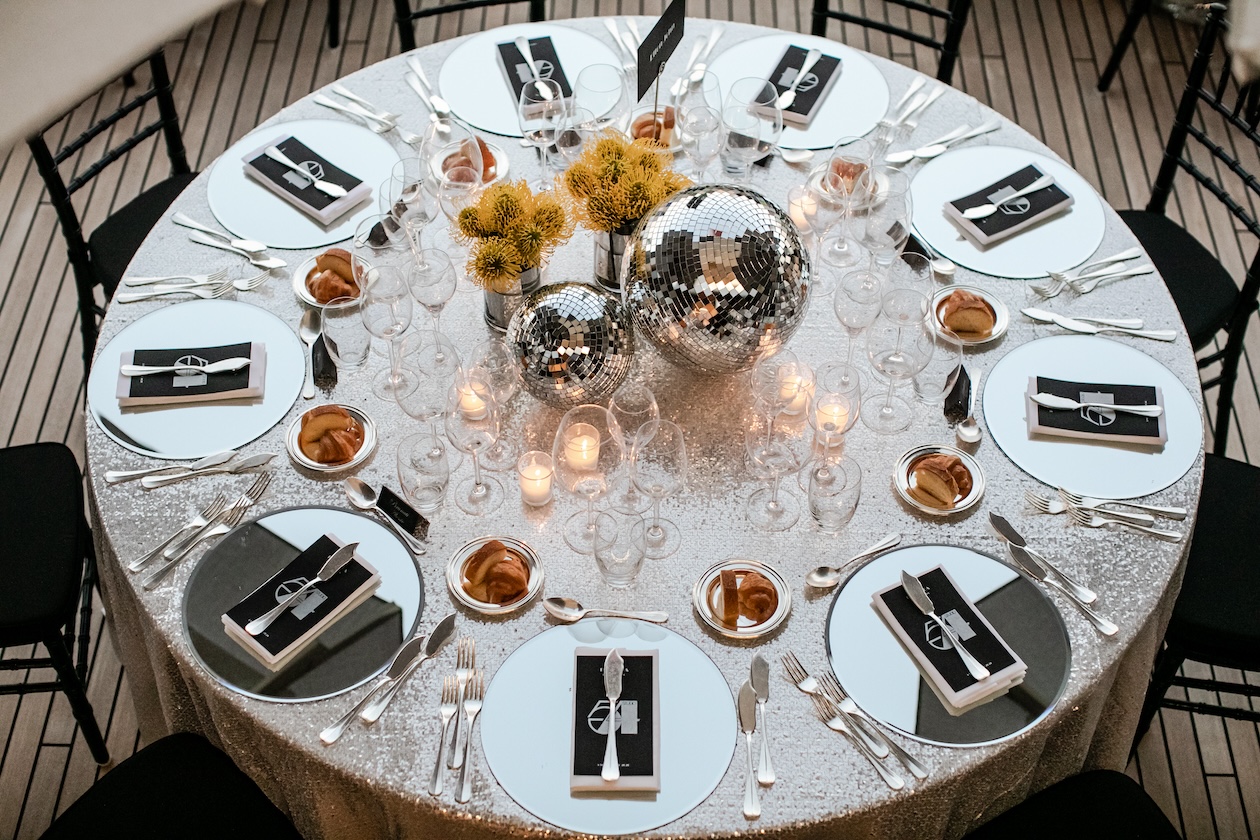 Top view of a round table set with candles and yellow flowers in the center. - ACCAELLE Events | Organizzazione eventi e Wedding planner