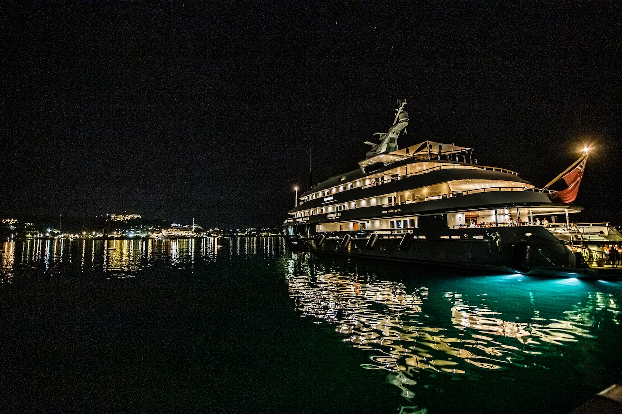 Illuminated luxury yacht taken from afar during the evening - ACCAELLE Events | Organizzazione eventi e Wedding planner