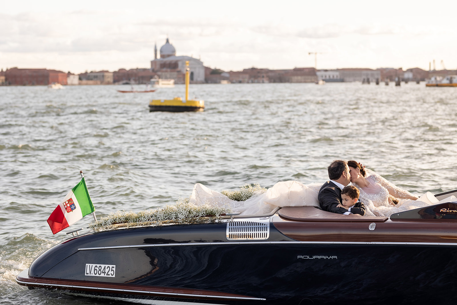 Bacio appassionato a pelo d'acqua e con Venezia sullo sfondo - ACCAELLE Events | Organizzazione eventi e Wedding planner