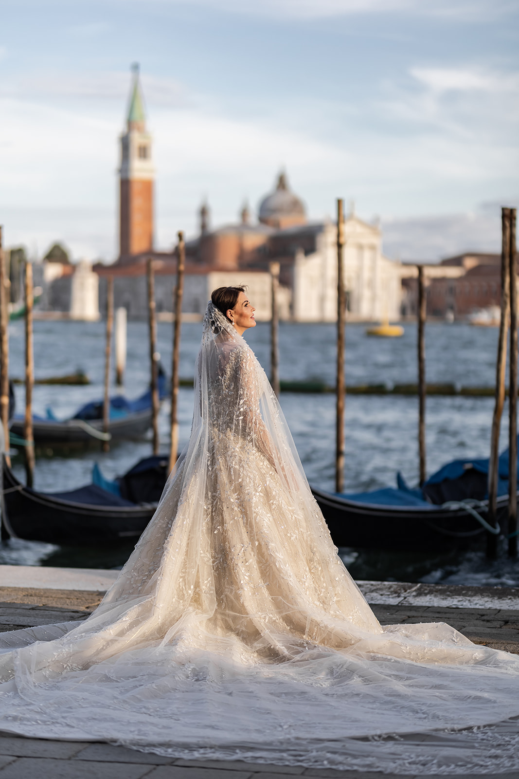 Sposa in posa con laguna sullo sfondo e palazzi di Venezia a fare da scenografia - ACCAELLE Events | Organizzazione eventi e Wedding planner