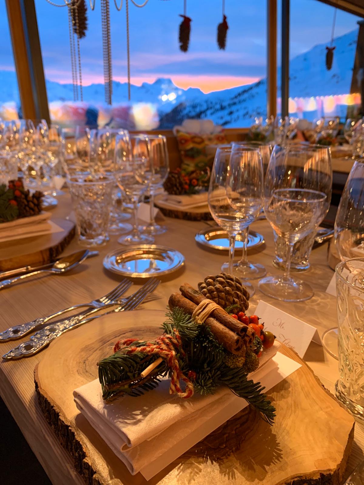 Allestimento elegante e rustico per una cena in montagna, con segnaposto in legno naturale decorati con pigne e bacche - ACCAELLE Events | Organizzazione eventi e Wedding planner