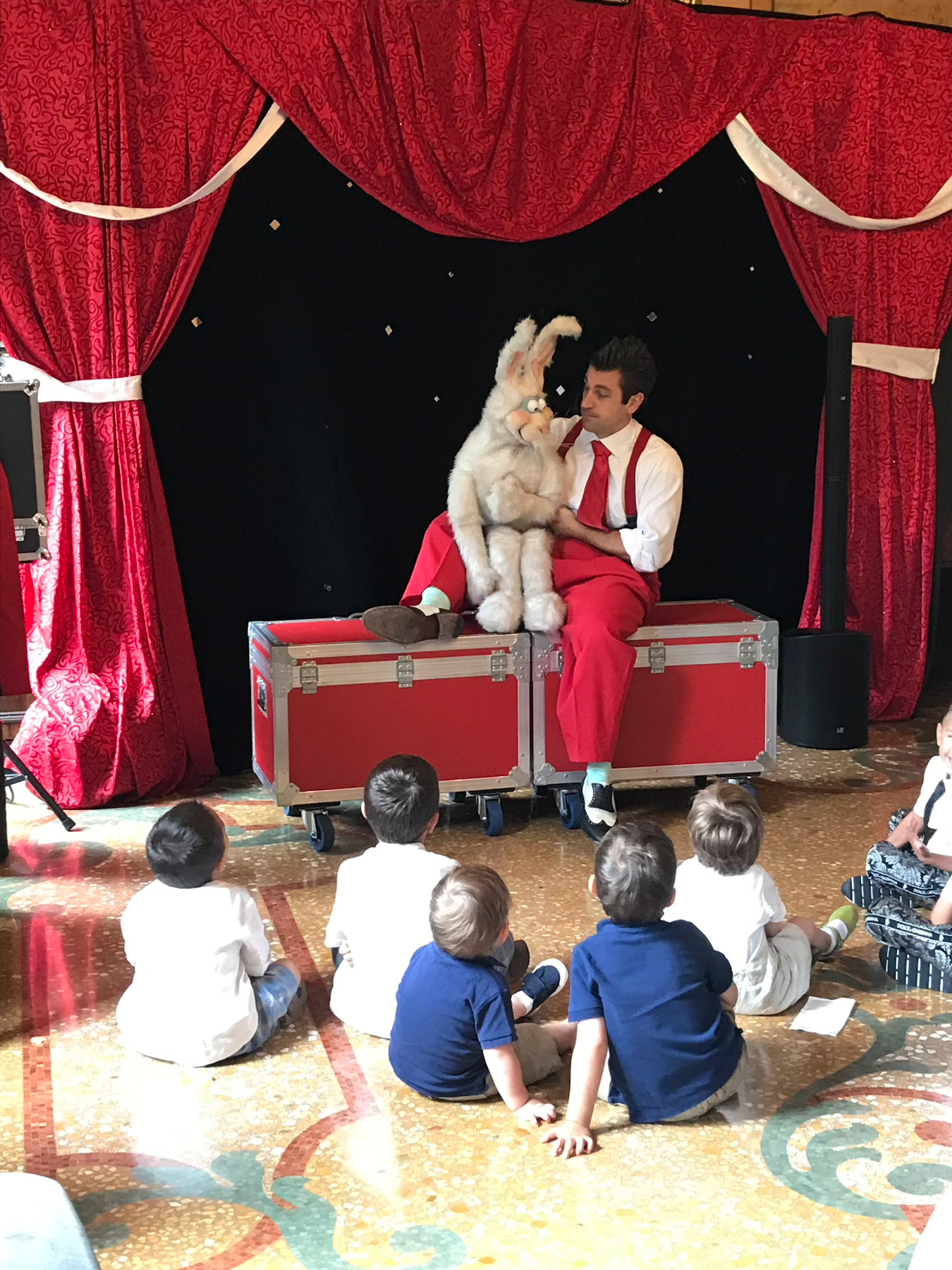 Artista con abito rosso che intrattiene bambini con pupazzo bianco - ACCAELLE Events | Organizzazione eventi e Wedding planner