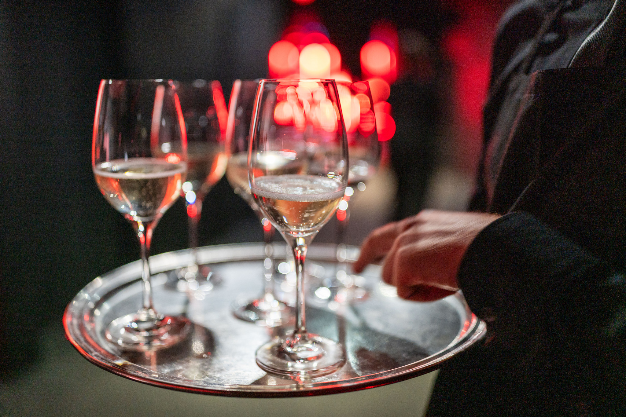 Cameriere che serve calici di spumante da un vassoio d'argento a una festa. - ACCAELLE Events | Organizzazione eventi e Wedding planner