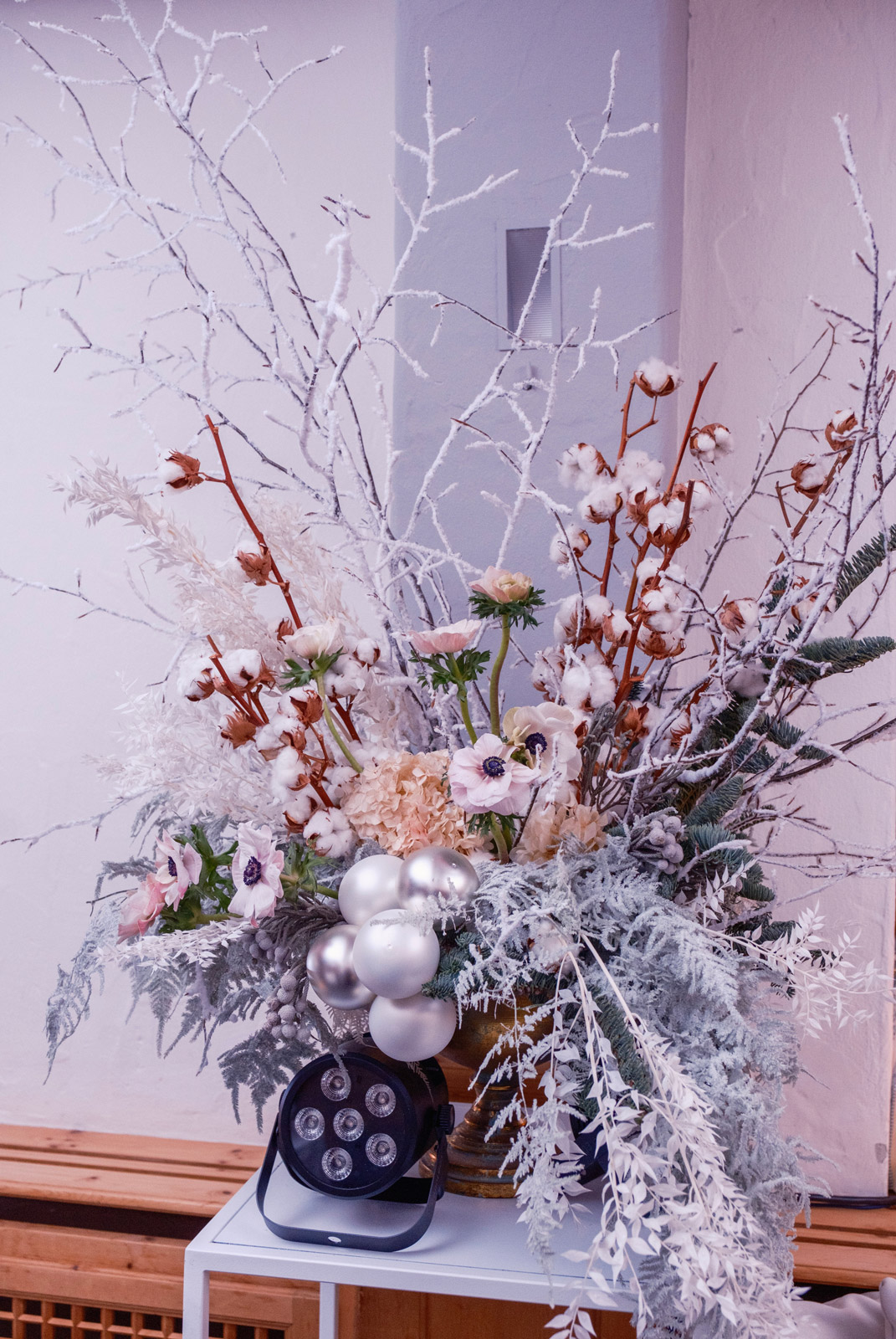 Composizione floreale artistica invernale con fiori bianchi, rami innevati, elementi in cotone e dettagli argentati - ACCAELLE Events | Organizzazione eventi e Wedding planner