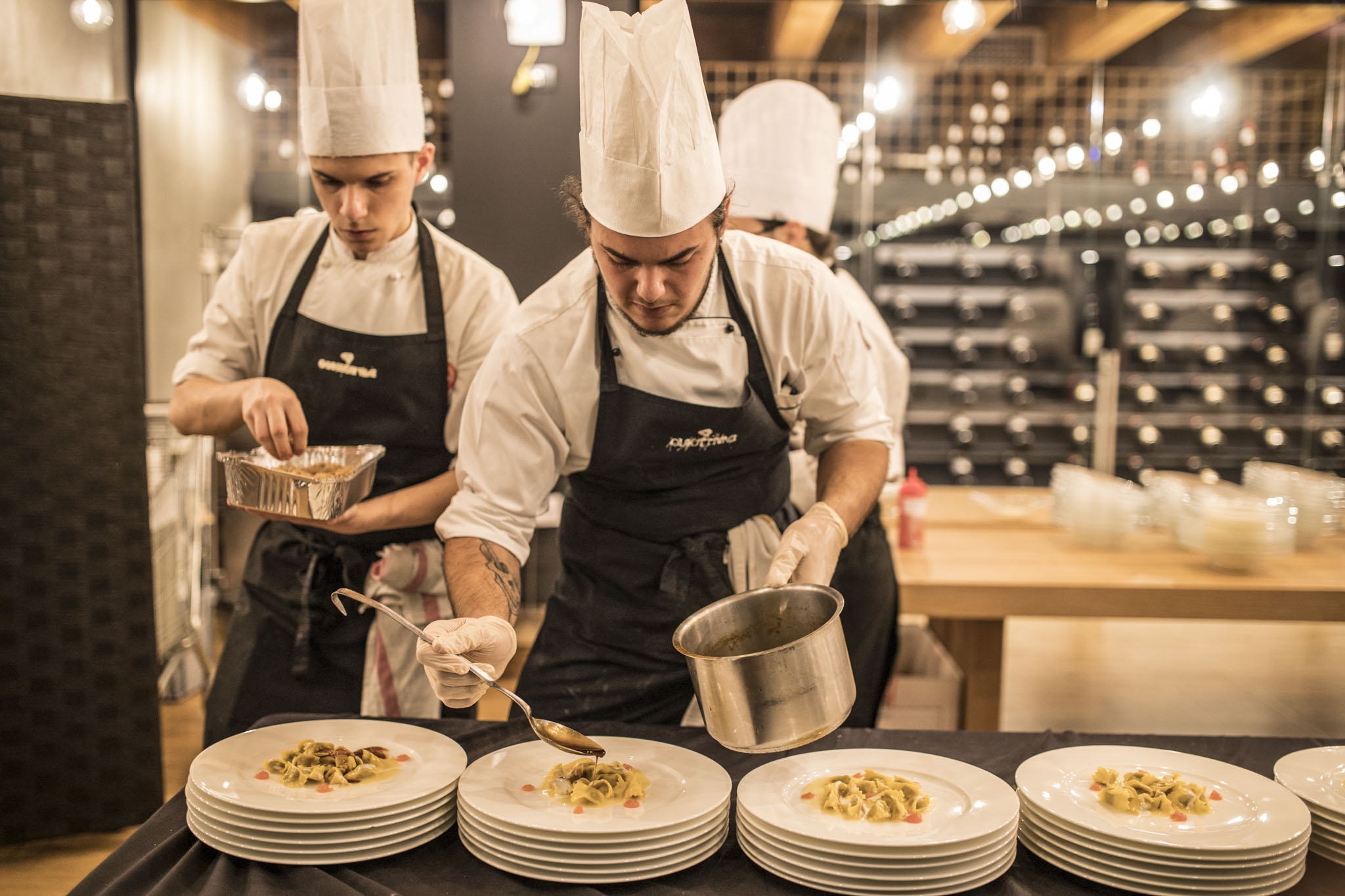Due chef con cappello alto concentrati a rifinire i piatti prima del servizio. - ACCAELLE Events | Organizzazione eventi e Wedding planner