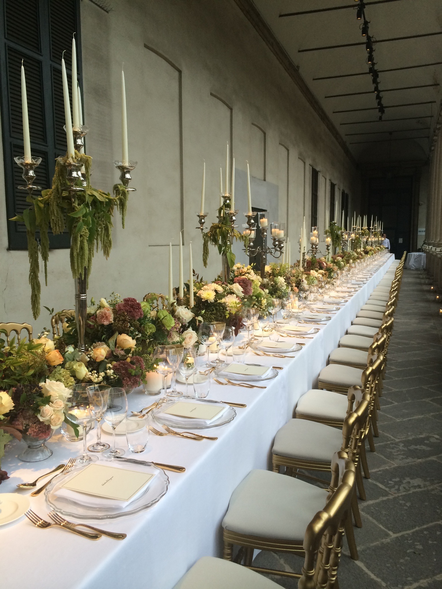  Lunghissimo tavolo imperiale apparecchiato sotto il porticato coperto di un palazzo storico. - ACCAELLE Events | Organizzazione eventi e Wedding planner