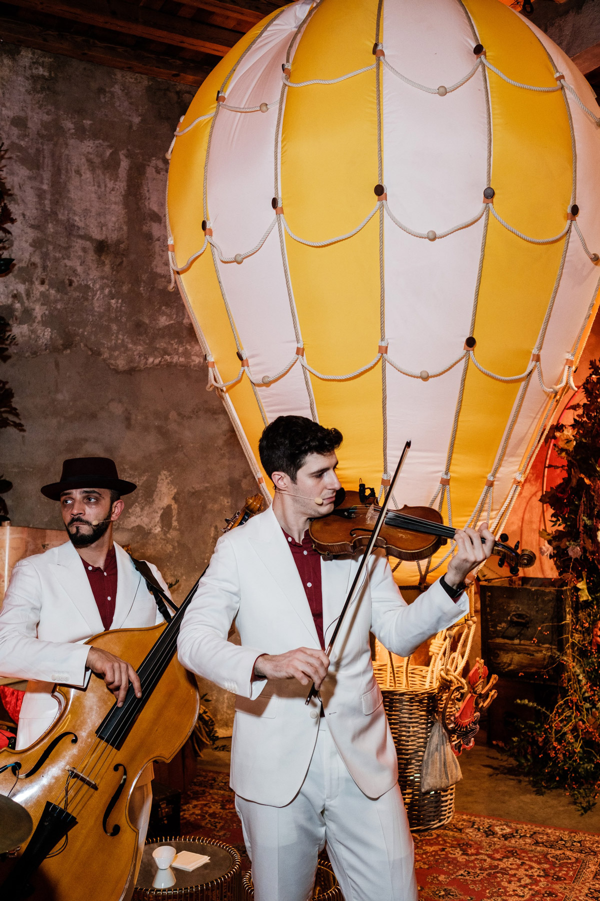 Musicisti che si esibiscono in abiti eleganti bianchi davanti ad una mongolfiera bianca e gialla - ACCAELLE Events | Organizzazione eventi e Wedding planner
