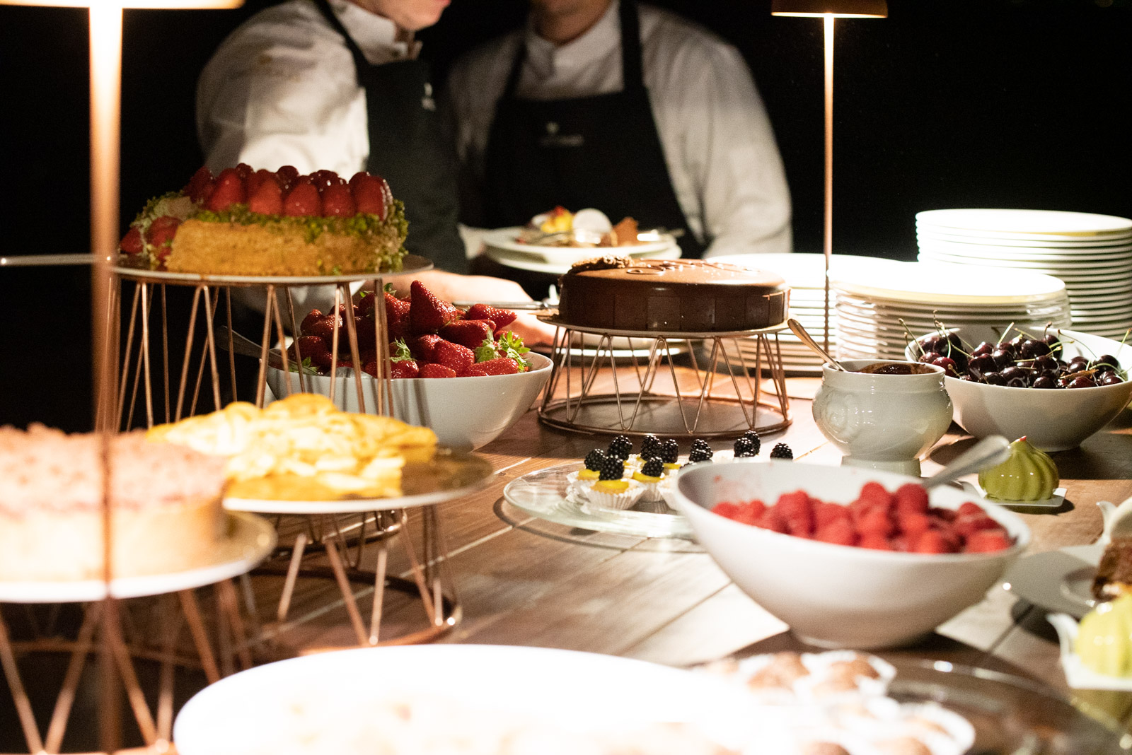 Primo piano buffet di dolci di sera con camerieri sullo sfondo - ACCAELLE Events | Organizzazione eventi e Wedding planner
